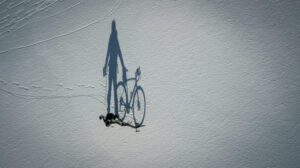 a shadow of a person riding a bike on snow
