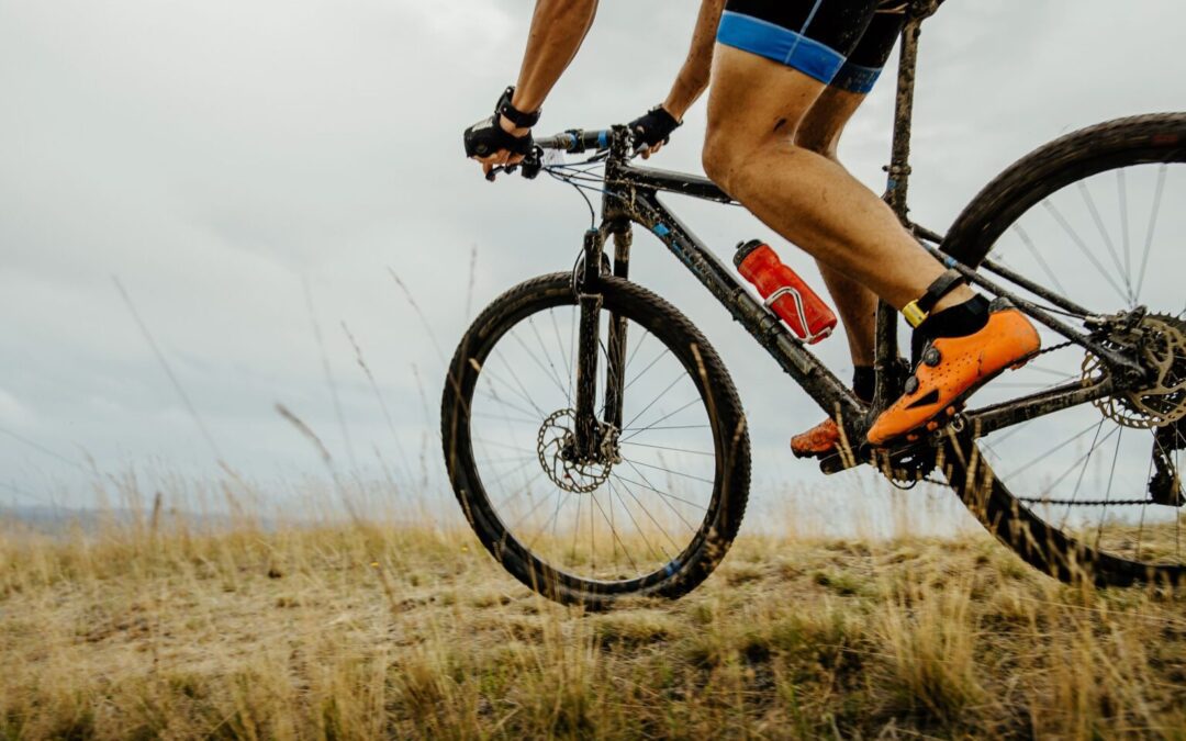 a person riding a mountain bike on a grassy hill