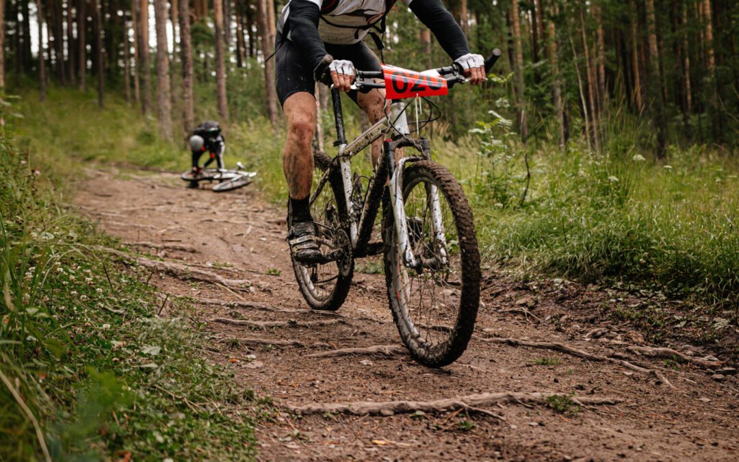 athlete cyclist riding forest trail on mountain bike