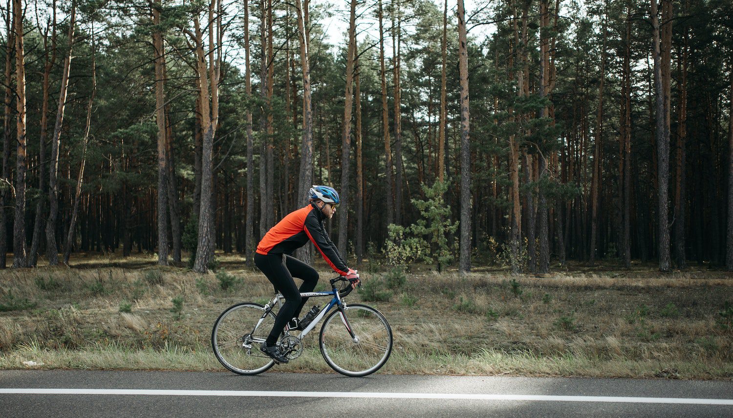 Man riding Black Bicycle on Roadside