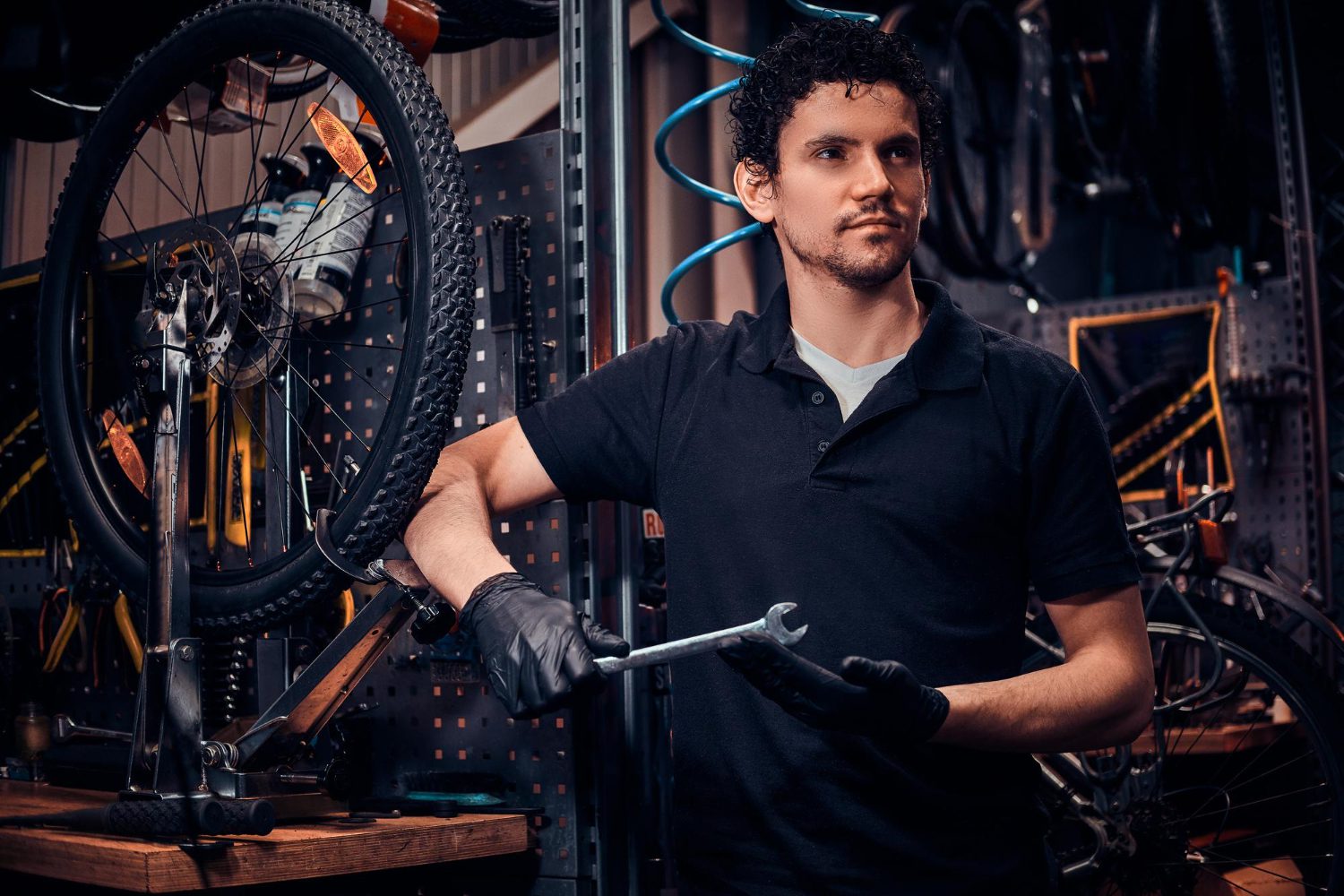 young attractive mechanic is posing bicycle his own workshop